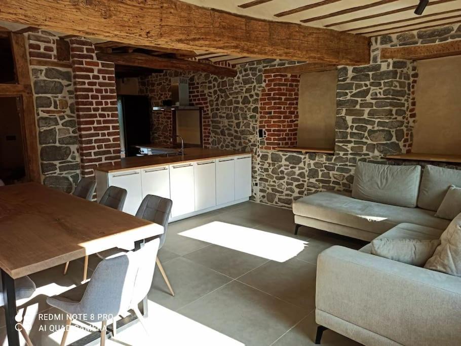 a kitchen and living room with a table and a couch at Ancienne ferme totalement rénové moderne à Baelen in Baelen