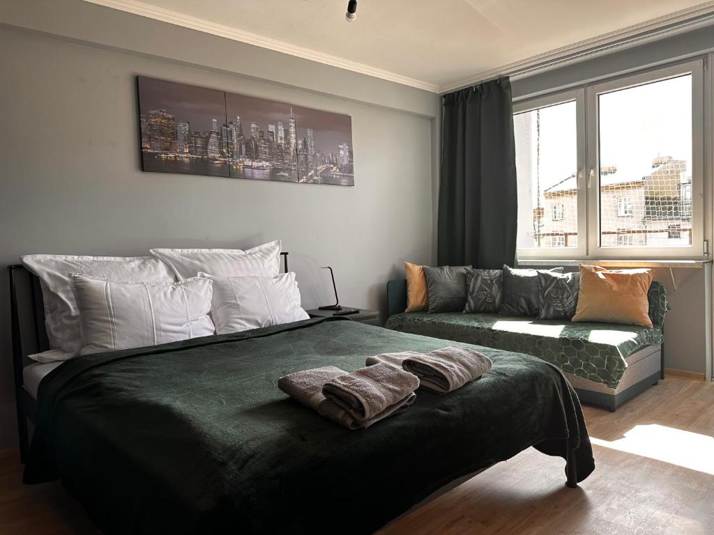 a bedroom with a large bed and a couch at Apartament Center Starowiślna in Krakow
