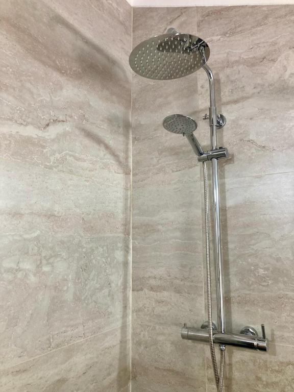 a shower with a shower head in a bathroom at Casa da Nazaré in Portinho da Arrábida