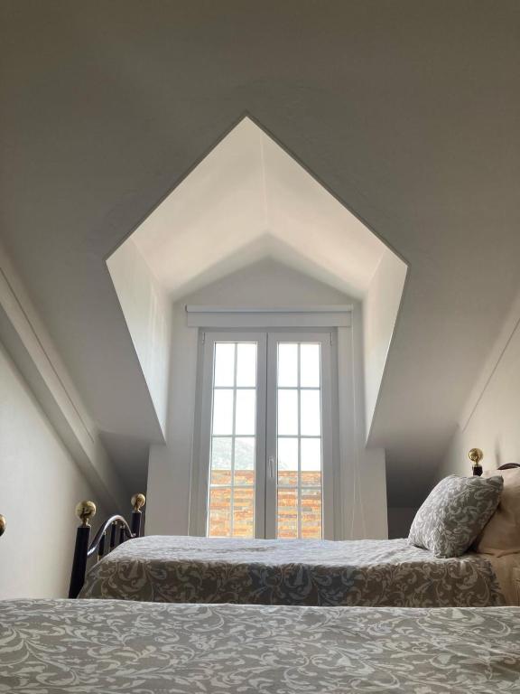 a bedroom with two beds and a large window at Casa da Nazaré in Portinho da Arrábida