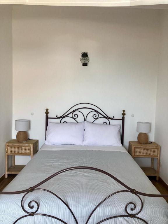 a bedroom with a large bed with two night stands at Casa da Nazaré in Portinho da Arrábida
