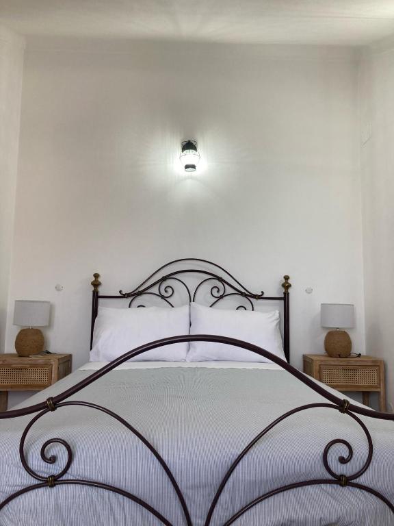 a bedroom with a bed with a wrought iron headboard at Casa da Nazaré in Portinho da Arrábida