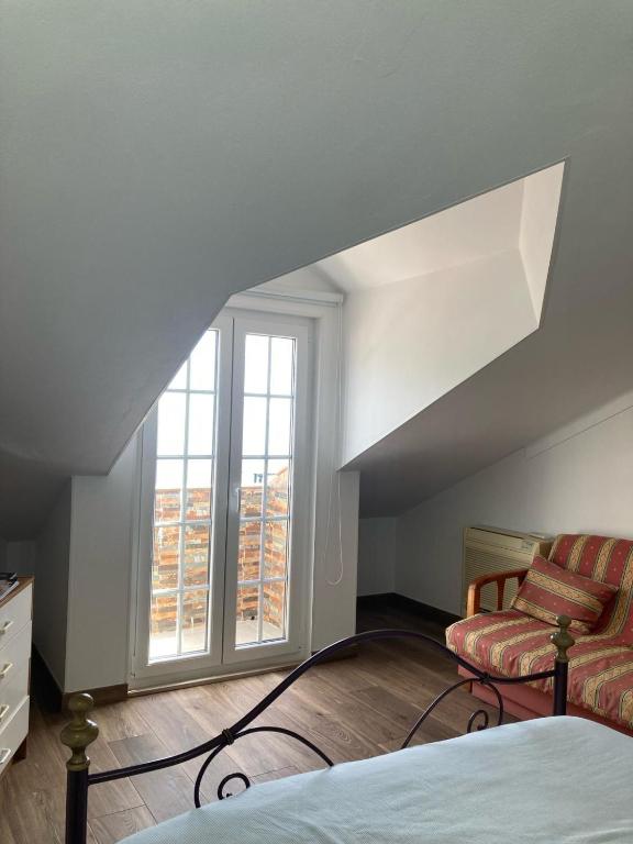 a bedroom with a bed and a chair and a window at Casa da Nazaré in Portinho da Arrábida