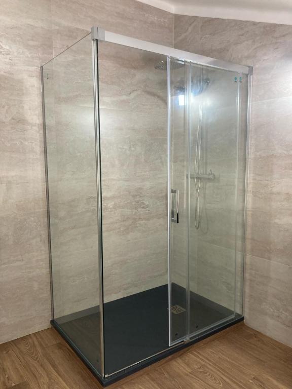 a shower with a glass door in a room at Casa da Nazaré in Portinho da Arrábida