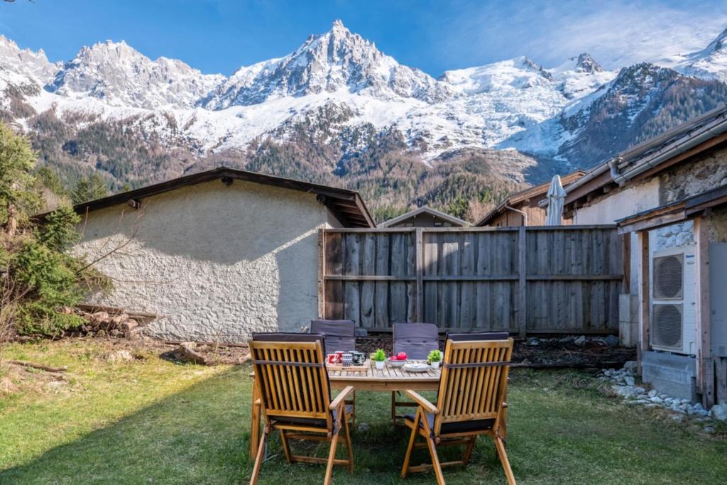 une table et deux chaises avec des montagnes en arrière-plan dans l'établissement Pretty loft with view of Mont Blanc & glacier, à Chamonix-Mont-Blanc