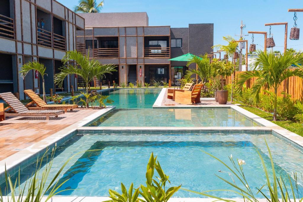a swimming pool in front of a building at Condomínio Gamboa Patacho a 190 da praia na Rota dos Milagres in Pôrto de Pedras
