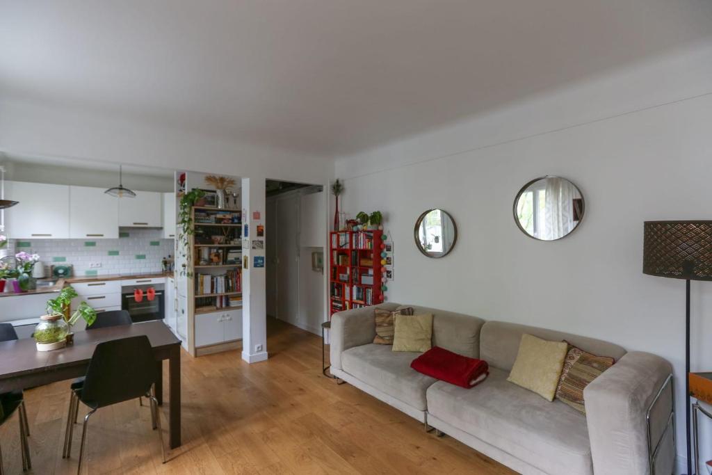 uma sala de estar com um sofá e uma mesa em Pretty cocoon at the doors of Paris em Vincennes