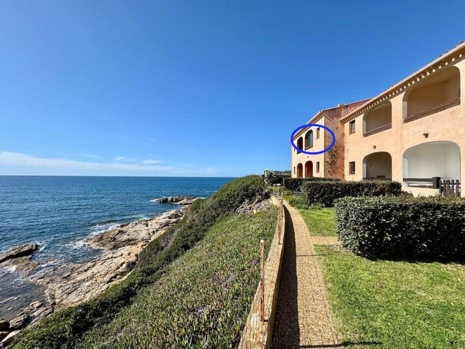 une maison sur une falaise à côté de l'océan dans l'établissement Appartement les pieds dans l'eau, à Calcatoggio