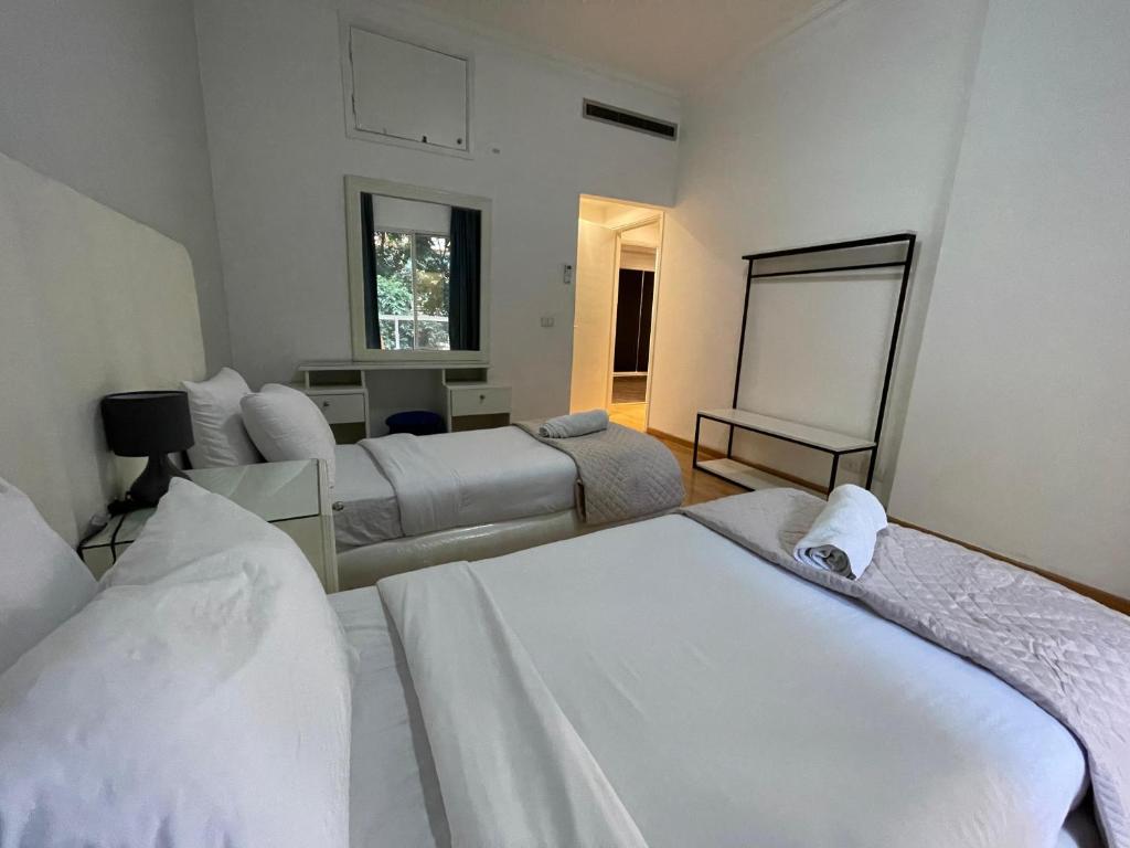 Zimmer mit 3 Betten und einer Tafel in der Unterkunft Elegant Suites Beirut in Beirut