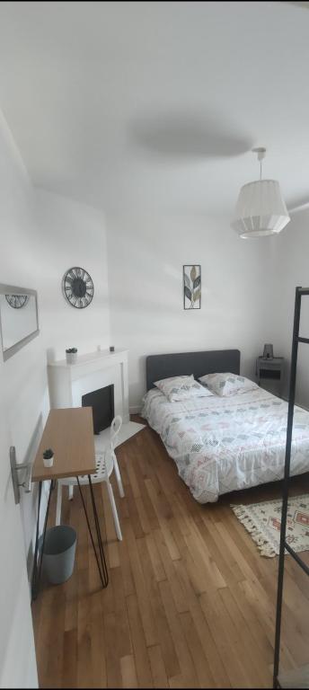 une chambre avec un lit, une table et un bureau dans l'établissement Appartement entier deux chambres, à Saint-Nazaire