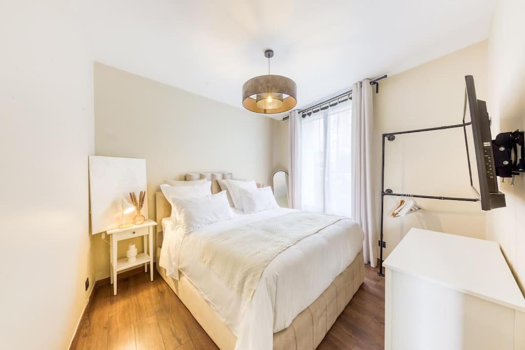 um quarto branco com uma cama grande e uma janela em Le splendide (Chic & Chaleureux) em Vincennes