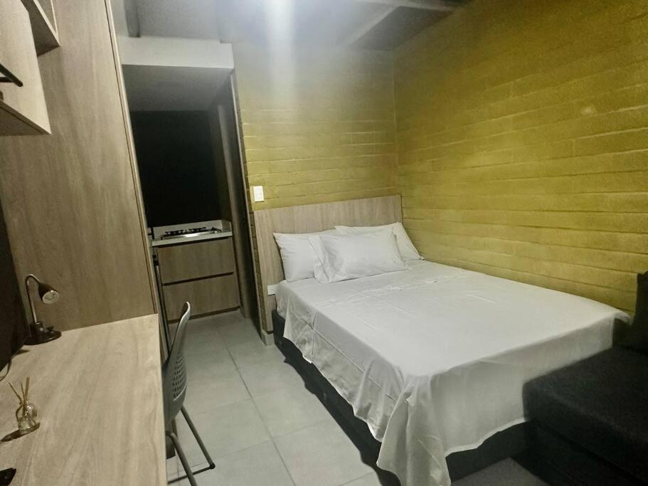 Kleines Zimmer mit einem Bett und einem TV in der Unterkunft Loft Belmont Suites (203) in Pereira