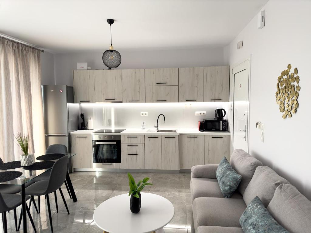 a kitchen and living room with a couch and a table at Sun Angelo luxury apartment in Paradise 2 in Arménoi