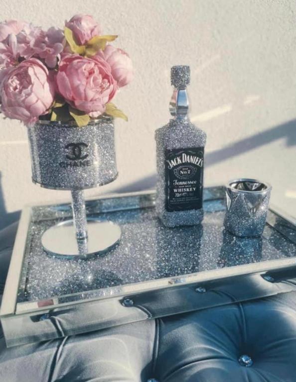 a bottle of whiskey and a vase with flowers on a table at Channel Centrum Deptak PKP PKS -zameldowanie -wymeldowanie bez kontaktowe in Kielce