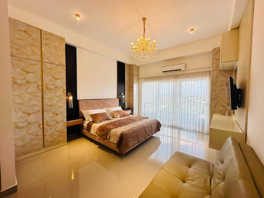 a bedroom with a bed and a chandelier at Grand Sri Lounge - Ocean Breeze Hotel residents in Negombo