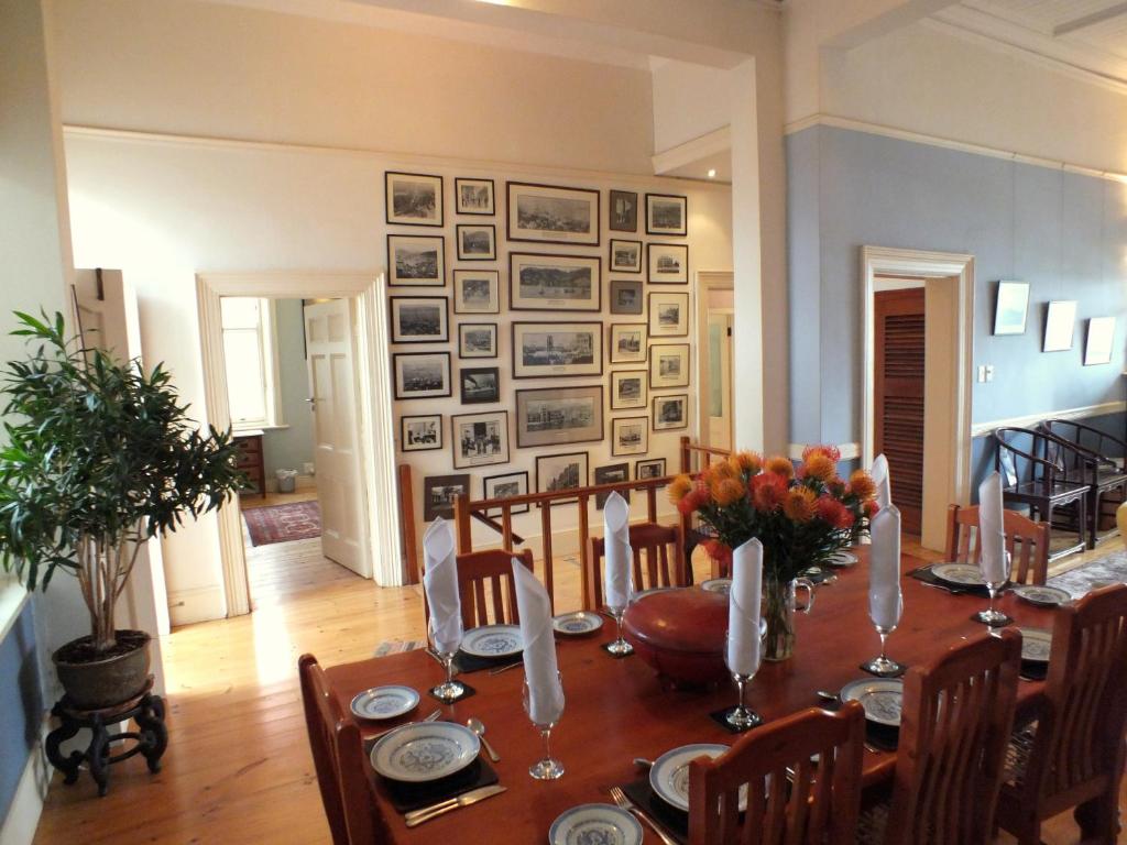 a dining room with a wooden table with chairs and a dining roomiasm at Braeside House Apartments in Cape Town