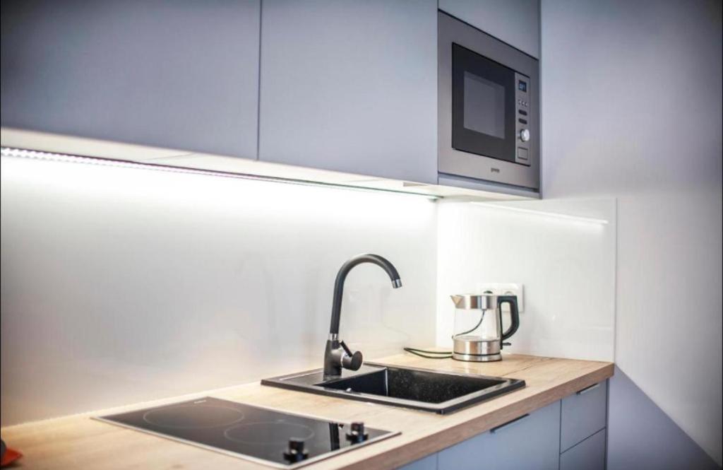 una cocina con fregadero y microondas en Channel na Wspólnej Centrum Deptak PKP PKS -Garaż Podziemny zameldowanie -wymeldowanie bez kontaktowe, en Kielce