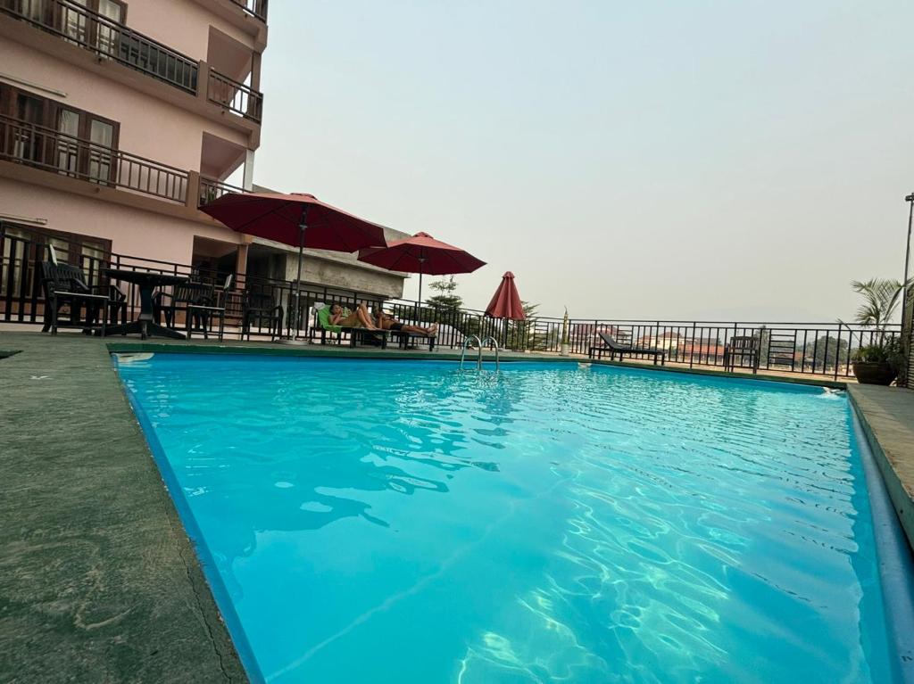 einem großen blauen Pool vor einem Gebäude in der Unterkunft Central Mountain View Hotel in Vang Vieng