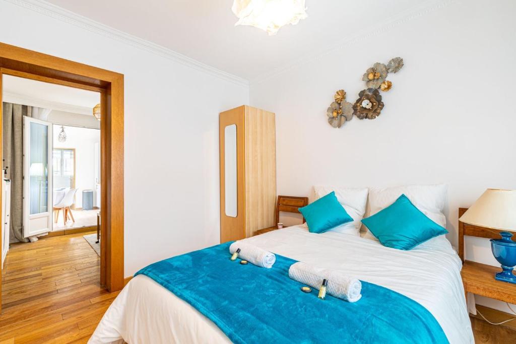 een slaapkamer met een groot bed met blauwe kussens bij Maison élégante 15 minutes de paris in Arcueil