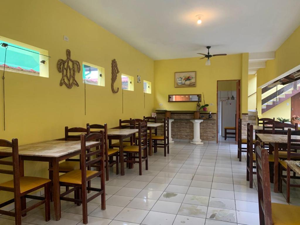 a dining room with wooden tables and chairs at Pousada Morada dos Pássaros in Caraguatatuba