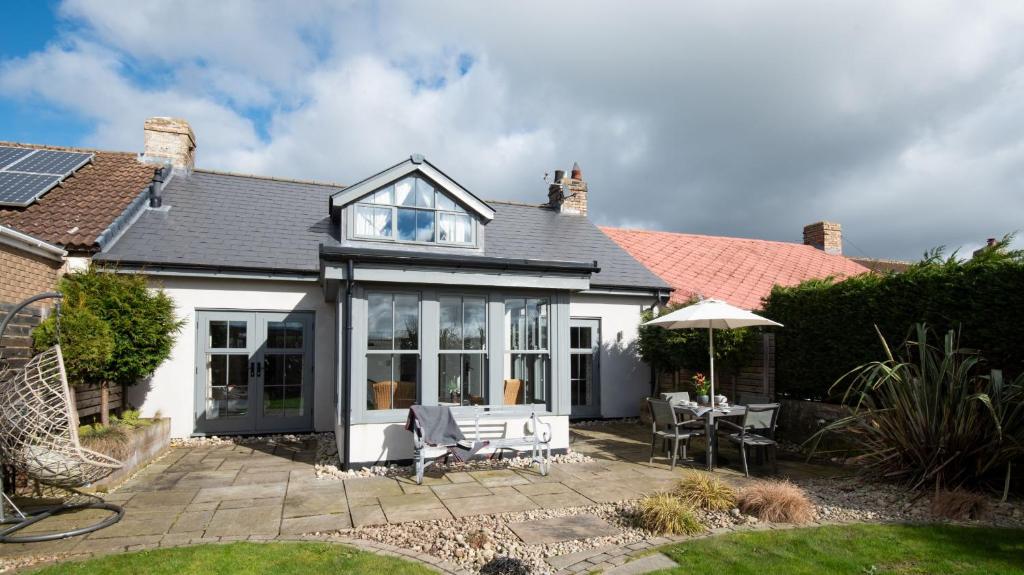 a white house with a patio with a table and chairs at Number Nine in Lanchester