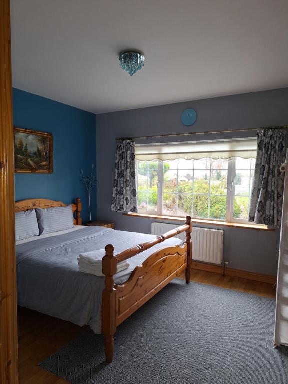 Un dormitorio con una cama grande y una ventana en Welcome to Tunmobi Villa, its home away from home., en Ballyjamesduff
