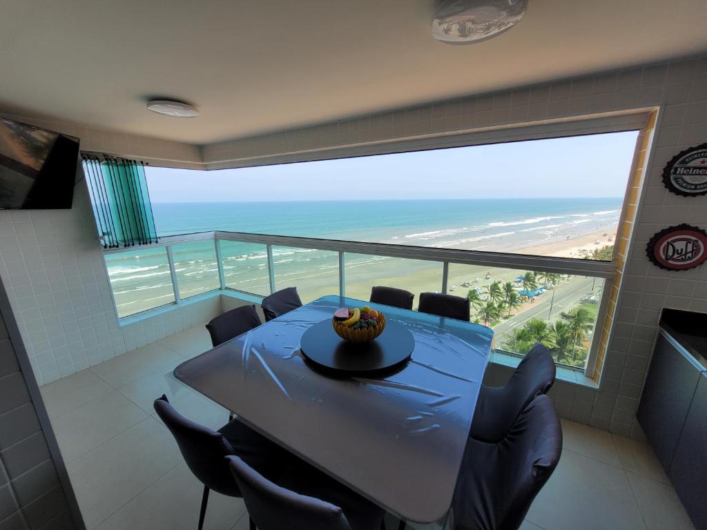 uma sala de jantar com uma mesa e vista para o oceano em Condomínio Firenze em Mongaguá