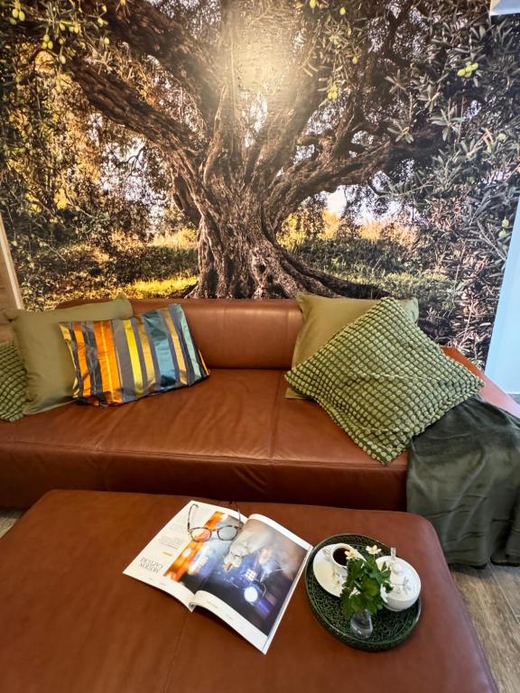 un divano marrone con un murale sull'albero di Apartment with a terrace Forest Home Lullula a Veprinac