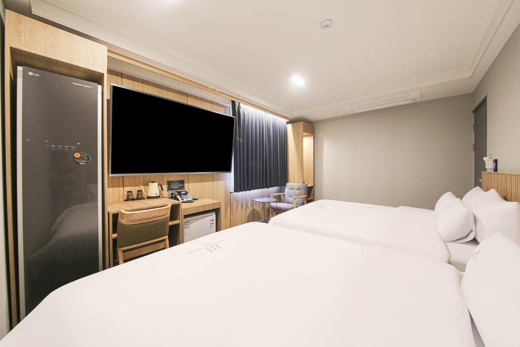 a hotel room with a bed and a flat screen tv at H Avenue Hotel Geumho in Gwangju