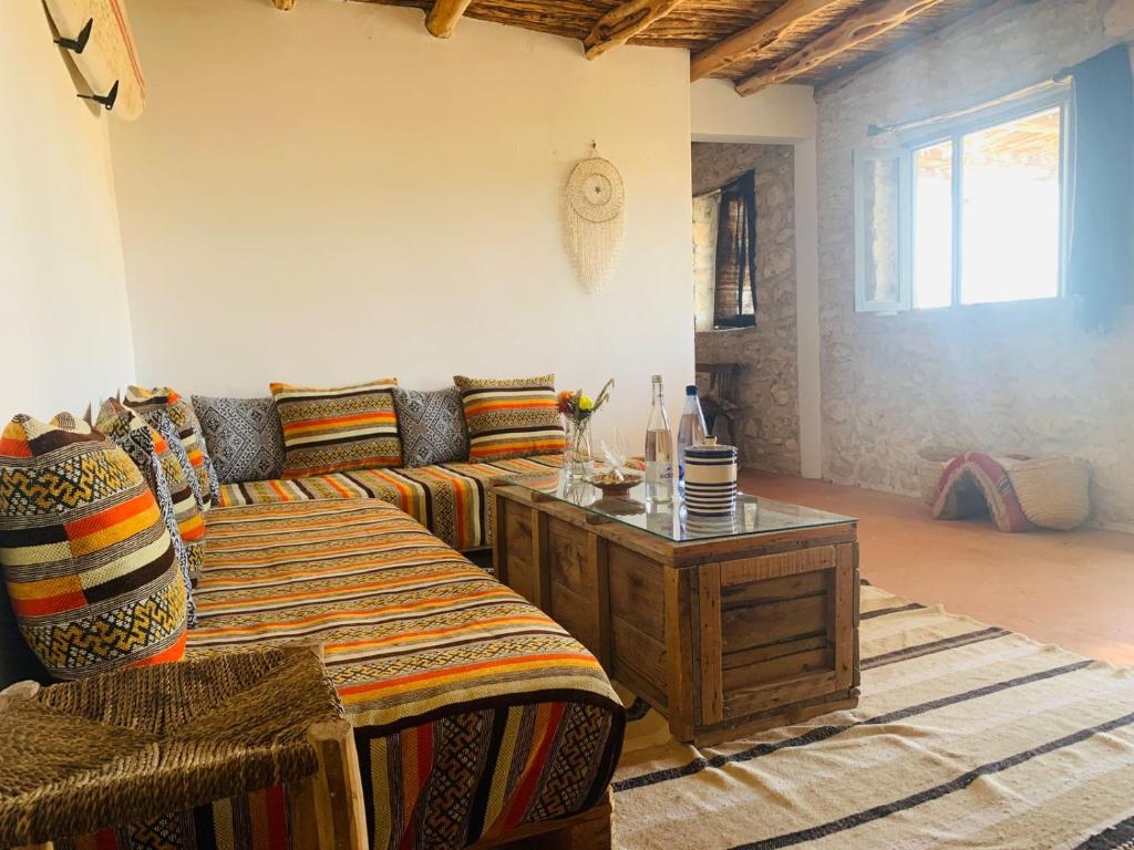 ein Wohnzimmer mit einem Sofa und einem Tisch in der Unterkunft Momo's beach house in Aghnajane
