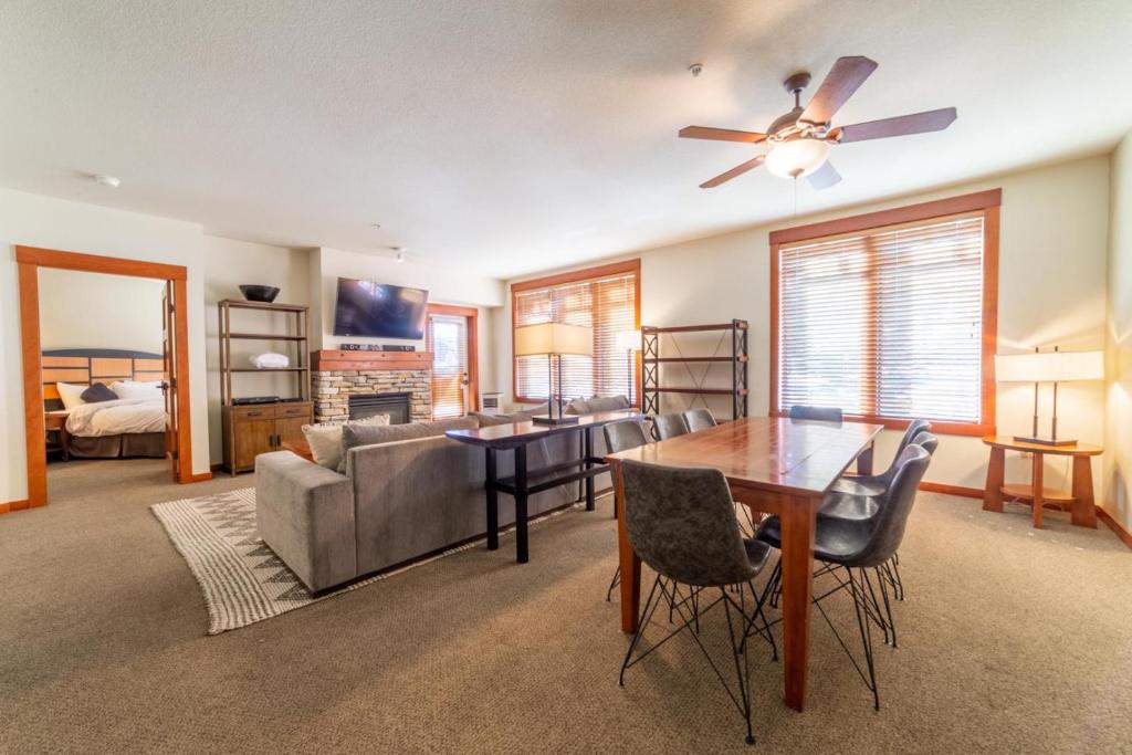 a living room with a ceiling fan and a table at #535- Village, Walk to Gondola, Restaurants, and Shops in Mammoth Lakes