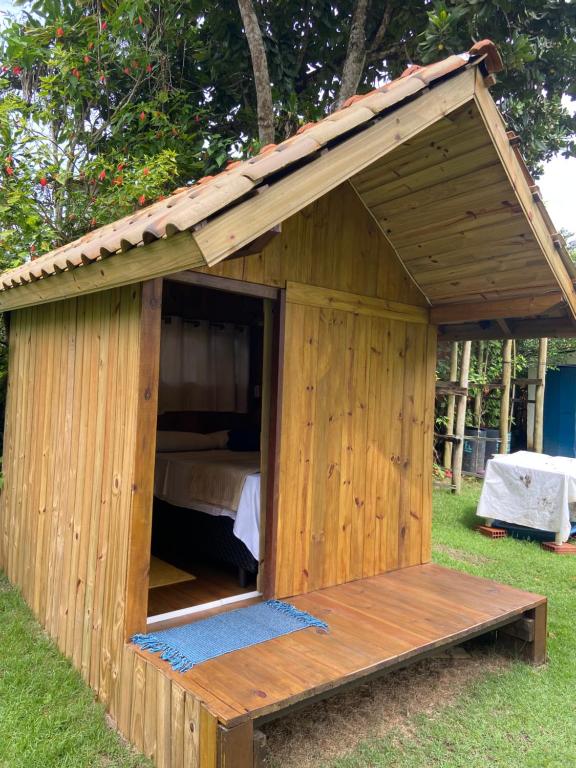 uma casa de cão de madeira com uma cama em Cabana Aloha em Paraty