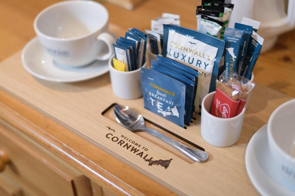 a wooden counter with cups and utensils on a table at The Britannia Inn & Waves Restaurant in Par