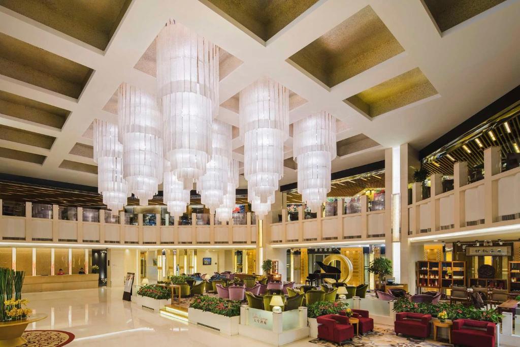 a large lobby with chandeliers in a hotel at Kempinski Hotel Dalian in Dalian