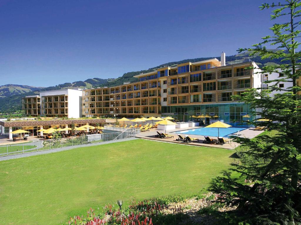 a large hotel with a large lawn in front of it at Kempinski Hotel Das Tirol in Jochberg