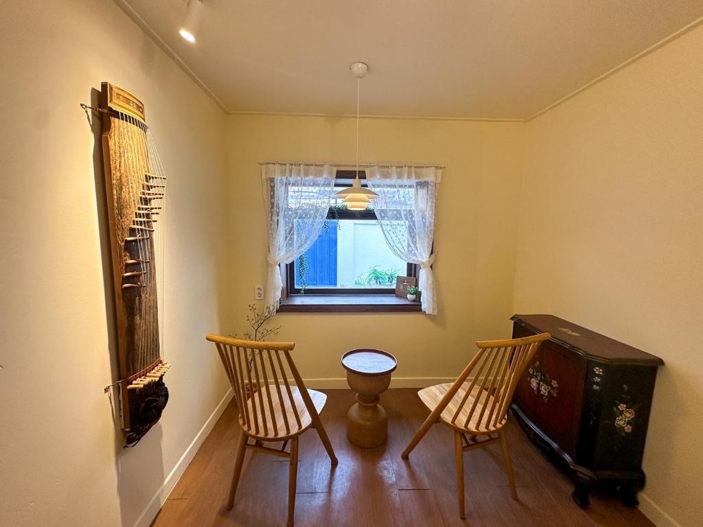 a room with two chairs and a table and a window at Yunseul- Garden House in the City with Korean Beauty in Seoul