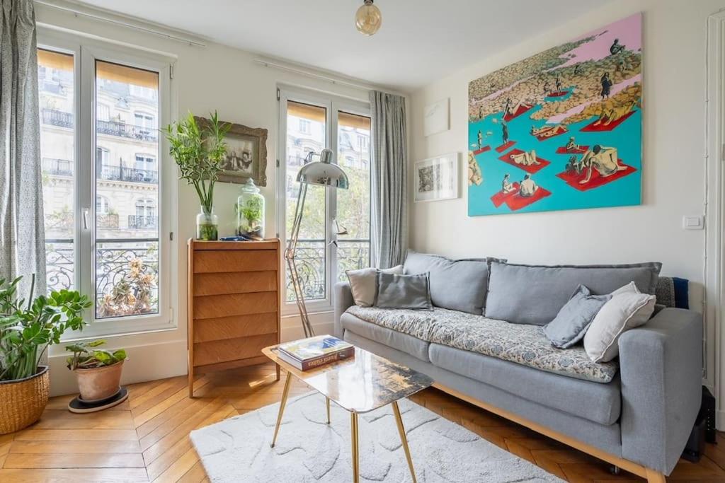un salon avec un canapé et une table dans l'établissement Bel appartement cosy, emplacement idéal, à Paris