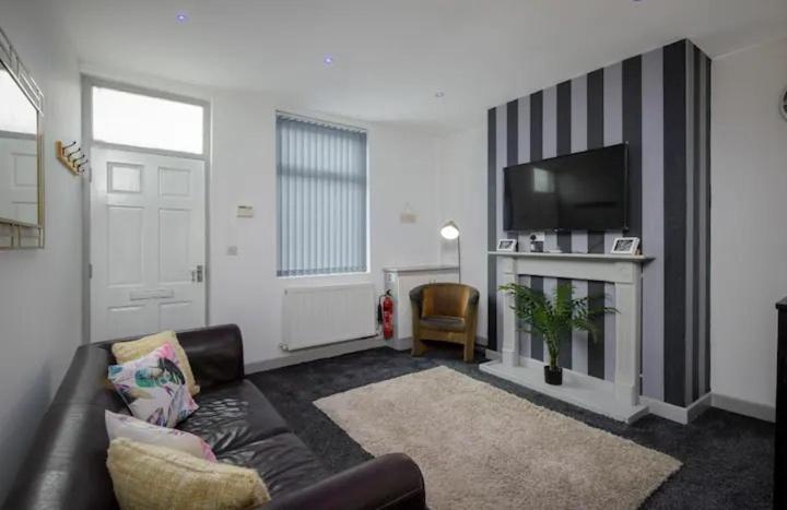 a living room with a couch and a flat screen tv at Vicarage House in Blackpool
