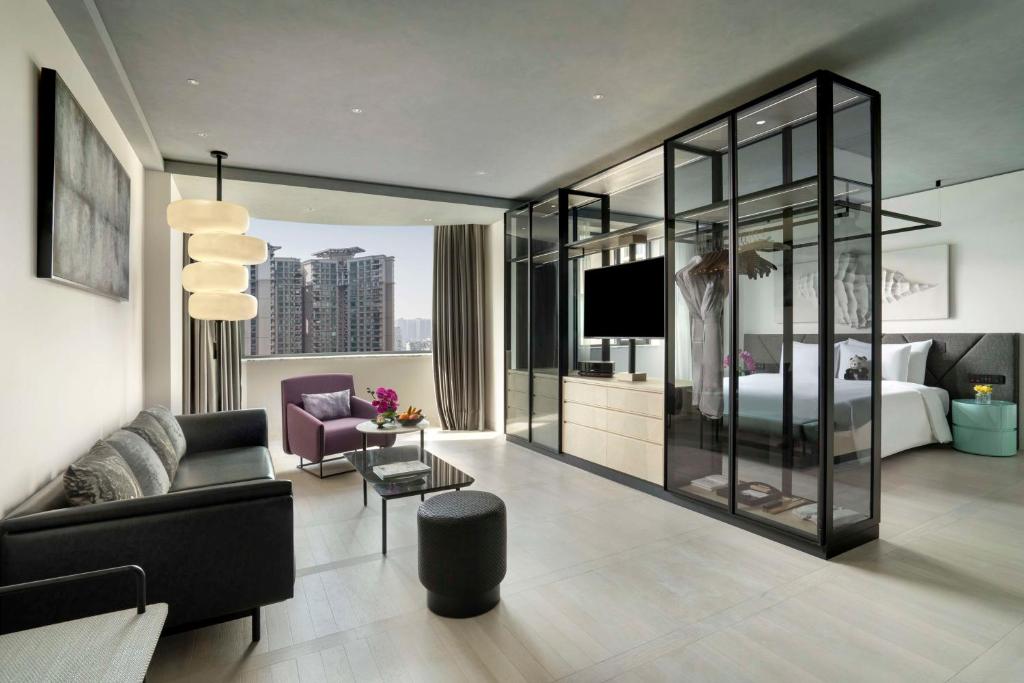 成都市にあるKempinski Hotel Chengdu-City Centerのベッドとリビングルームが備わるホテルルームです。