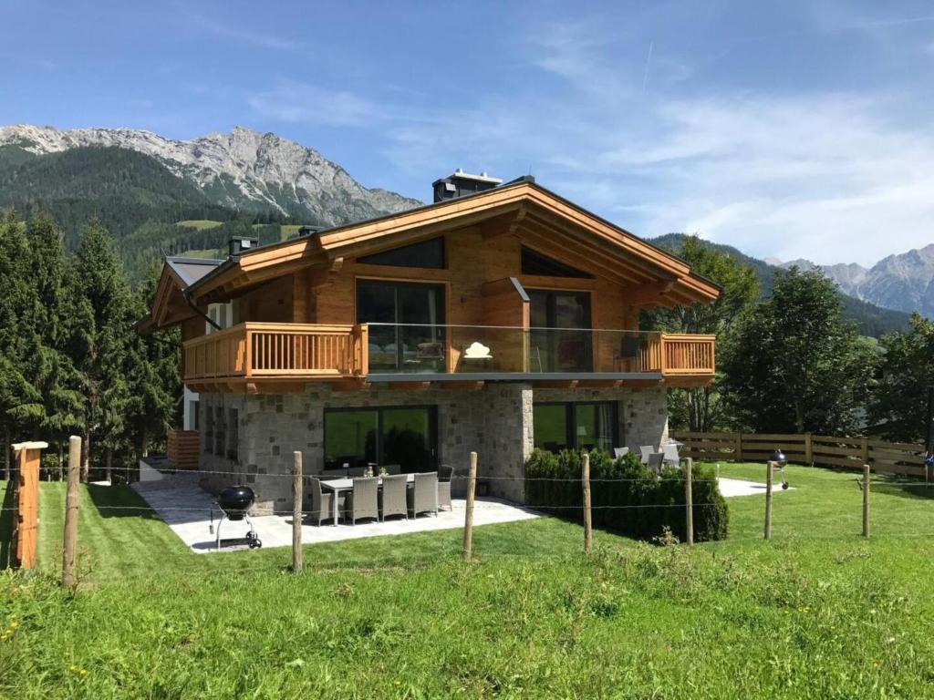 a house in a field with mountains in the background at Schneeflocke Leogang in Leogang