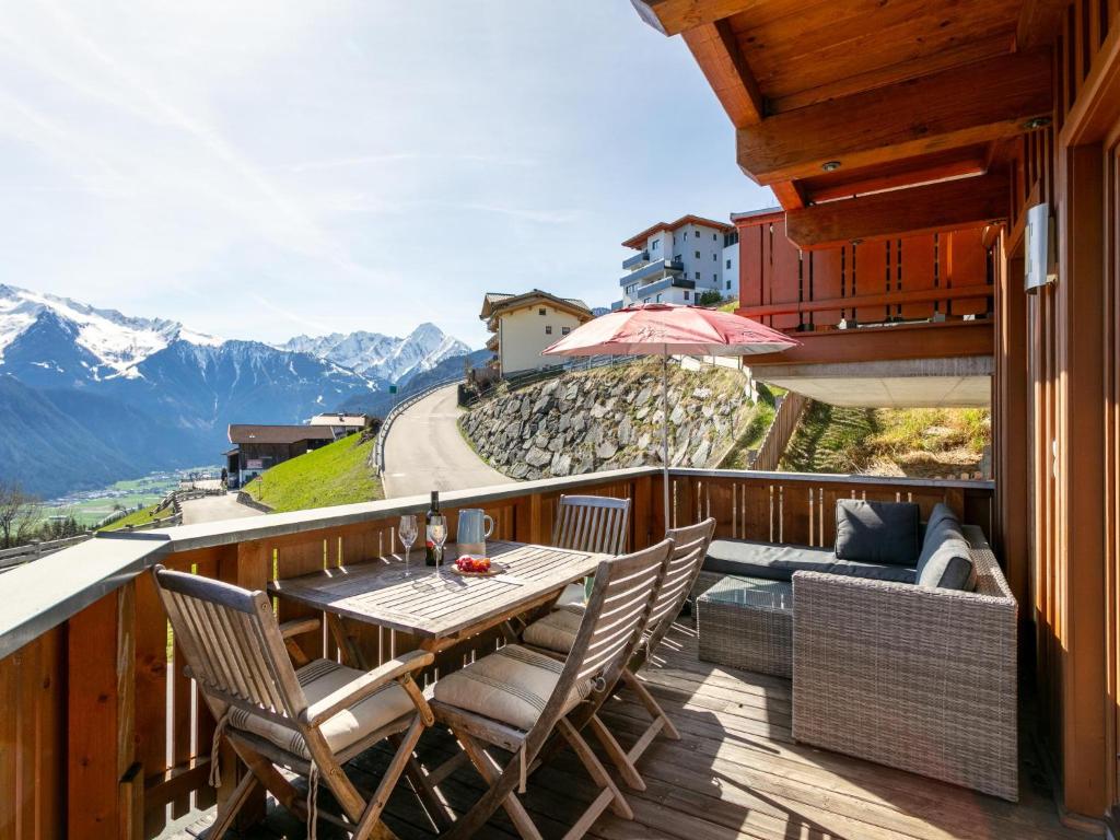 a balcony with a table and chairs and mountains at Hoog Hout in Hippach