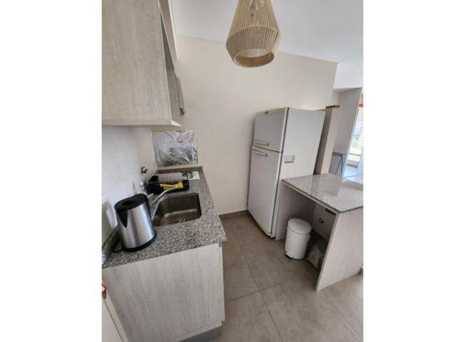 a small kitchen with a sink and a refrigerator at Alsina 125 in Junín