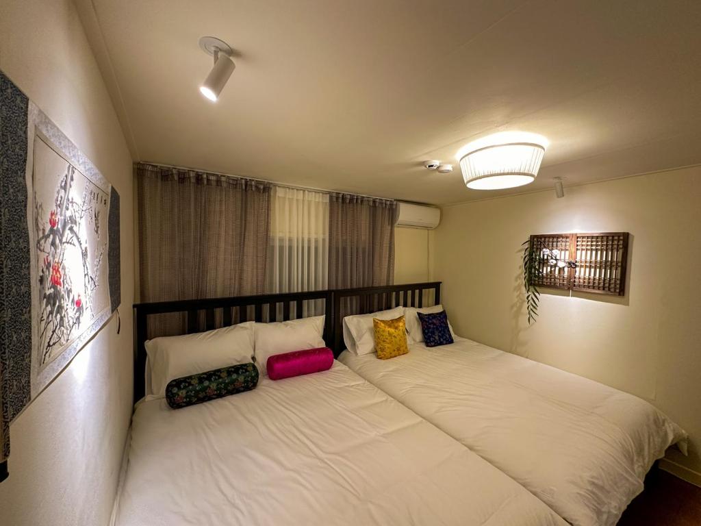 a bedroom with a large bed with pillows on it at Yunseul- Garden House in the City with Korean Beauty in Seoul