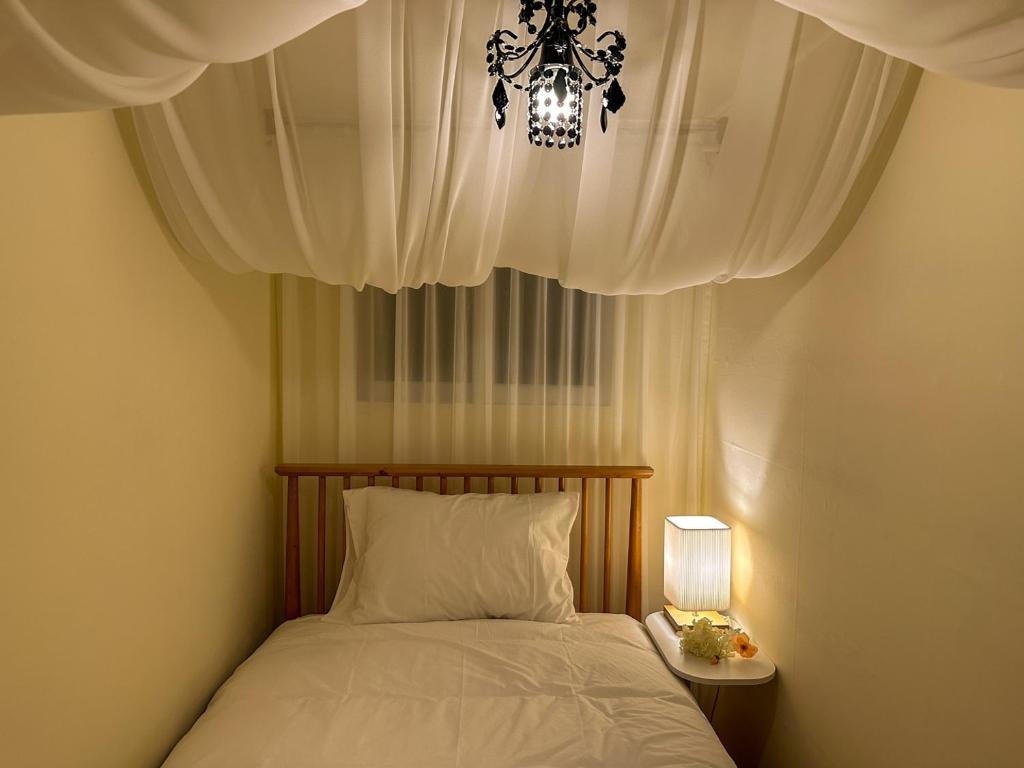 a bedroom with a bed with a chandelier and a lamp at Yunseul- Garden House in the City with Korean Beauty in Seoul