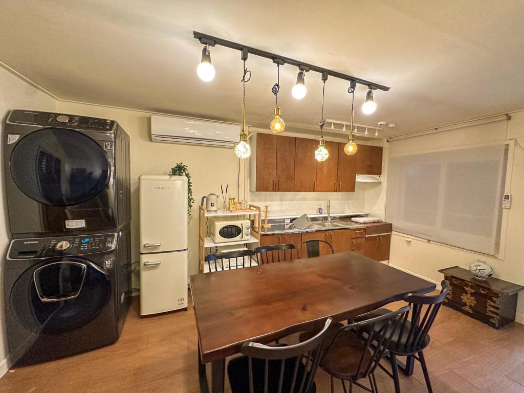 a kitchen with a wooden table and a dining room at Yunseul- Garden House in the City with Korean Beauty in Seoul