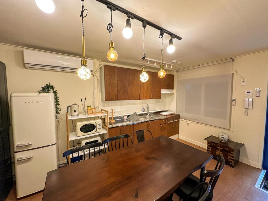 a kitchen with a wooden table and a dining room at Yunseul- Garden House in the City with Korean Beauty in Seoul