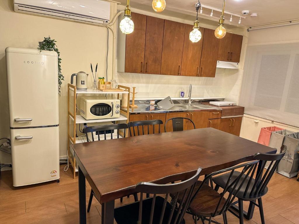 a kitchen with a wooden table and a refrigerator at Yunseul- Garden House in the City with Korean Beauty in Seoul
