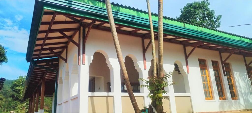 uma pequena casa branca com um telhado verde em 360 Mount Villa - Peacock Hill em Gampola