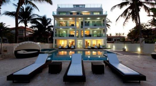 une grande maison avec une piscine en face de celle-ci dans l'établissement Watermark Luxury Oceanfront Residences, à Cabarete