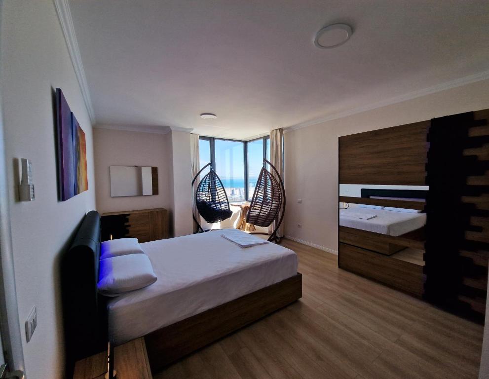 a bedroom with two beds and a large mirror at Absolut Vollga in Durrës